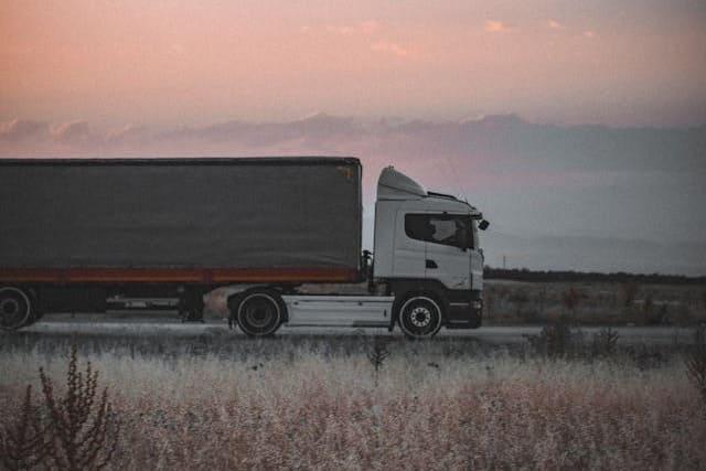 Un camión en una carretera con una puesta de sol.