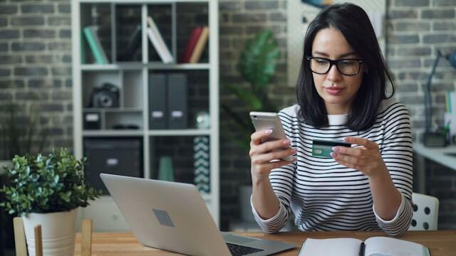 Une femme confirme un achat avec son portable