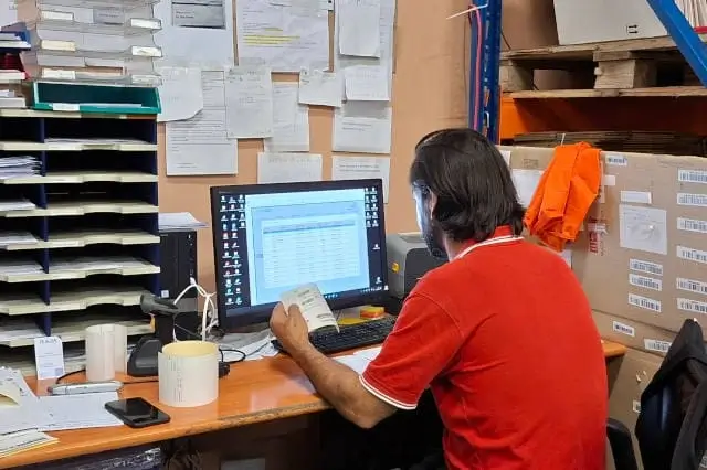 A logistics specialist enters orders into the warehouse management system.
