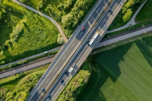 Une autoroute entourée de verdure vue du ciel.
