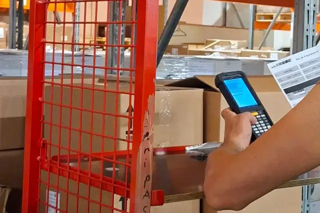 Un employé regarde les commandes sur son scanner.